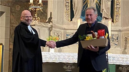 Propst Jens Höfel gratuliert Küster Jakob Hinkel zum Dienstjubiläum.