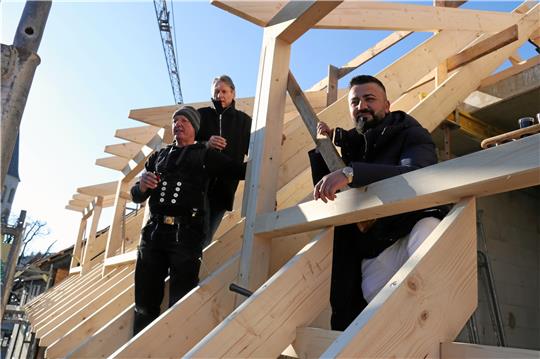 Prosit und Gottes Segen: Polier Helmut Peters (von links), Architekt Markus Schmidt und Bauherr Taher Kado trinken auf die Zukunft des neuen Hotels. Fotos: Hartmann