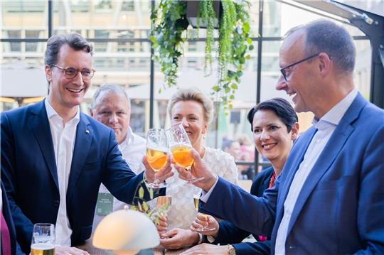 Prost: NRW-Ministerpräsident Hendrik Wüst (l) und CDU-Chef Friedrich Merz stoßen mit einem Bier mieinander an.