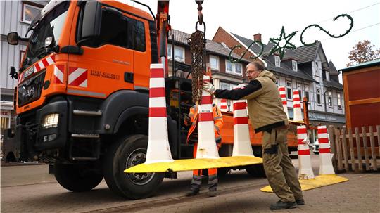 Zwei Personen heben die City Safes mit einem Kran vom Lkw