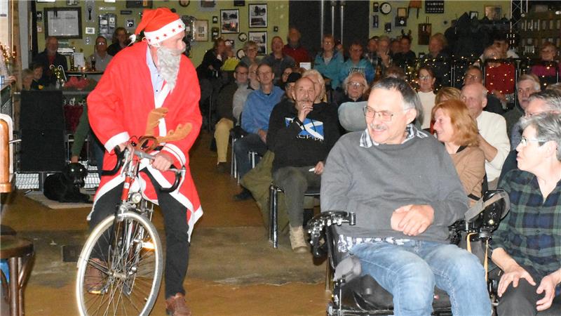 Ein Weihnachtsmann radelt durchs Kulturkraftwerk. Die Menschen staunen.