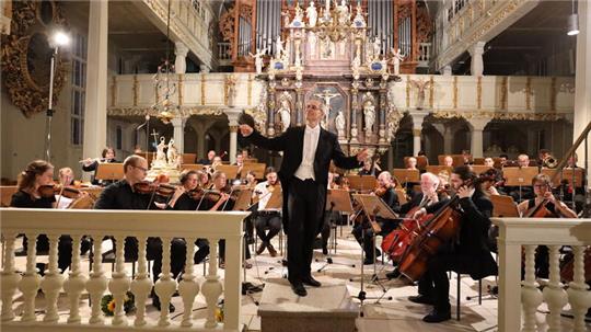 Rainer Klugkist dirigiert nicht nur sein TU-Sinfonieorchester, sondern zum Schluss auch das Publikum beim Singen des Steigerlieds.