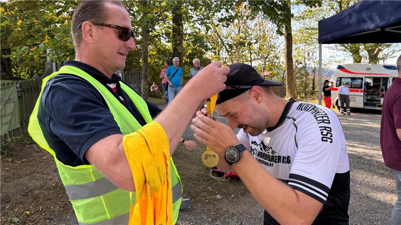 Ralph Bogisch vom Rotary-Club Goslar hängt jedem Läufer im Ziel eine Medaille um (im Bild Matthias Krause aus dem Nordharz, der auf der Zwölf-Kilometer-Strecke 13. wird).