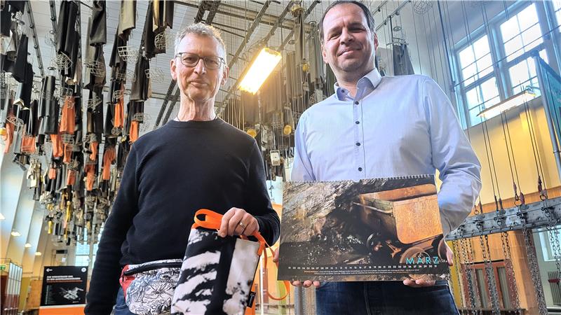 Rammelsberg-Chef Dr. Johannes Großewinkelmann (li.) und Pressesprecher Dr. Martin Wetzel präsentieren die neuen Angebote aus dem Museumsshop: ein Kalender mit Besucherfotos und Taschen, die aus alten Ausstellungsbannern gefertigt werden.