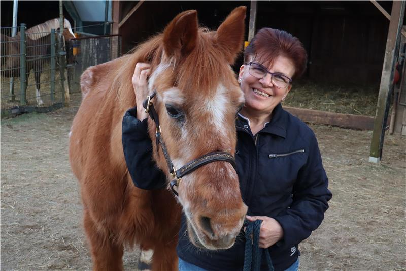 Frau hält ein Pony am Halfter. 