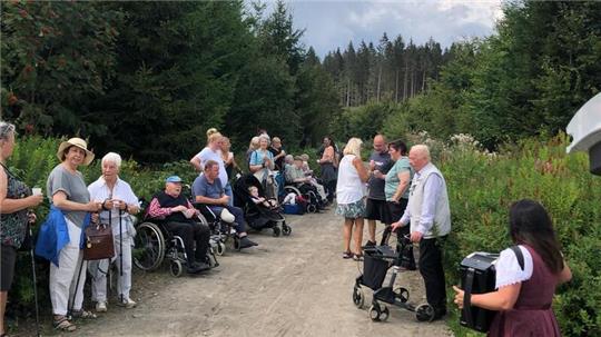 Rast am Langeliether-Grabenweg. Die Jodelmeisterin Marina Hein (im Vordergrund rechts) singt und musiziert Volkslieder zum Mitsingen.