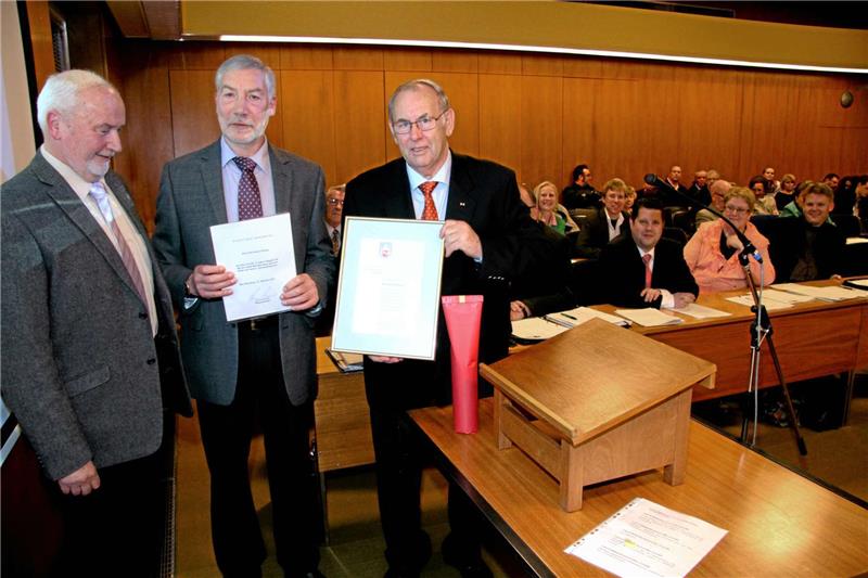 Ratsvorsitzender Udo Raders und Bürgermeister Ralf Abrahms ehren Bernhard Düsing (v.l.).