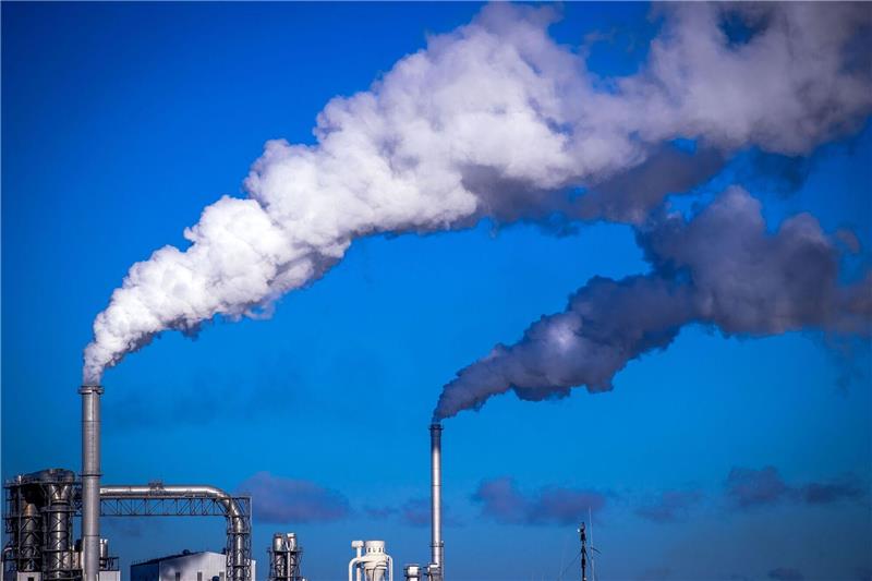 Globale CO2-Emissionen weiter auf Rekordniveau Rauch steigt aus Schornsteinen von holzverarbeitenden Industriebetrieben am Seehafen Wismar auf.