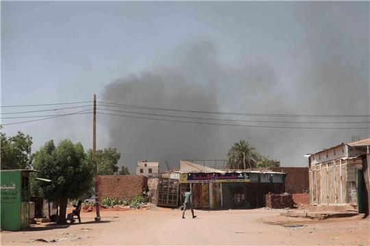 Rauch steigt hinter Gebäuden auf. Viele Menschen sind auf der Flucht vor dem Konflikt im Sudan.