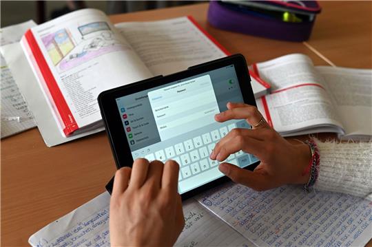 Realschüler einer zehnten Klasse einer Gemeinschaftsschule arbeiten in einer Unterrichtsstunde mit Tablets.