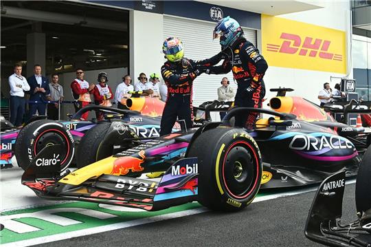 Red-Bull-Pilot Sergio Pérez (l) gratuliert seinem Teamkollegen Max Verstappen zum Sieg.