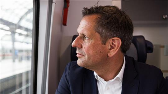 Regierungschef Lies blickt bei einer Zugfahrt von Hannover nach Berlin aus dem Fenster.