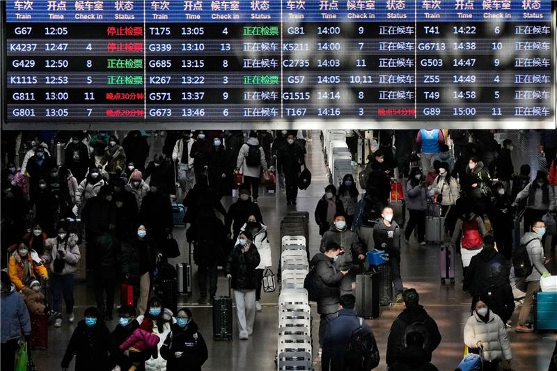 Neujahrsfest in China: Reisewelle verbreitet Virus rasanter Reisende mit ihrem Gepäck gehen unter einer Zugabfahrtstafel am Westbahnhof in Peking.