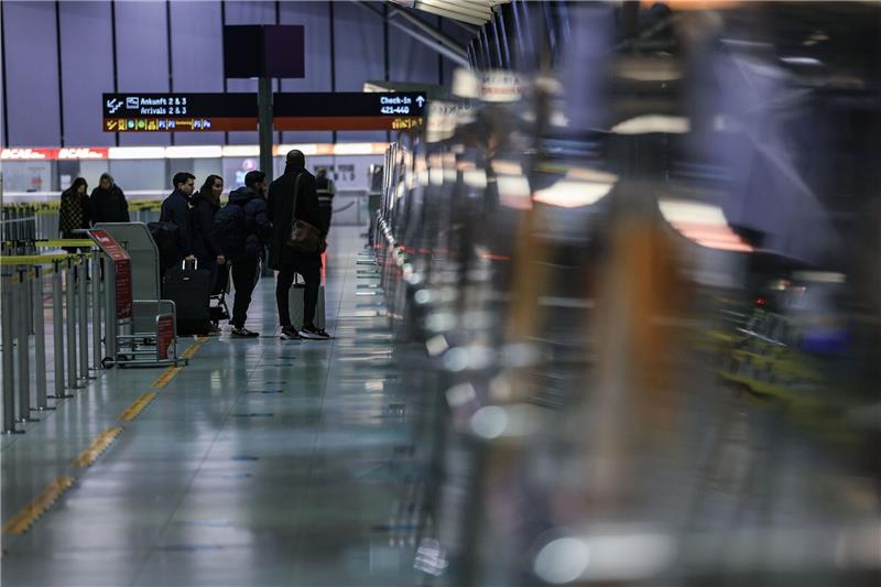 Länder wollen Chaos bei Flugpassagier-Kontrollen beenden Reisende stehen am Flughafen Köln/Bonn vor einem Schalter.