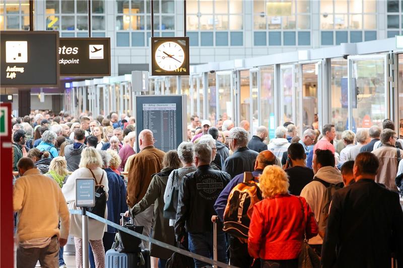 Bundesbürger in Reiselaune - Herausforderung für Flughäfen Reisende warten in langen Schlangen vor der Sicherheitskontrolle am Flughafen Hamburg auf die Abfertigung.