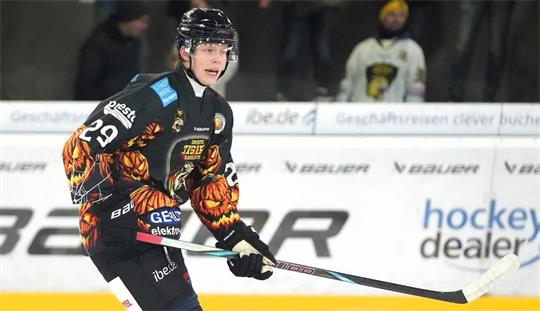 Eishockeyspieler in schwarzer Ausrüstung mit Flammenmuster auf dem Eis in Spielhaltung