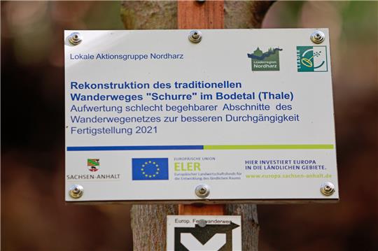 „Rekonstruktion des traditionellen Wanderweges «Schurre» im Bodental (Thale)“ steht auf einem Schild am Wanderweg. Ein Wanderer ist im Harz etwa 100 Meter einen Abhang hinuntergestürzt und gestorben. Wie die Polizei am Samstag mitteilte, ereignete sich der Unfall am Freitagnachmittag im Bodetal nahe Thale im Landkreis Harz auf dem Wanderweg «Schurre». Foto: Matthias Bein/dpa