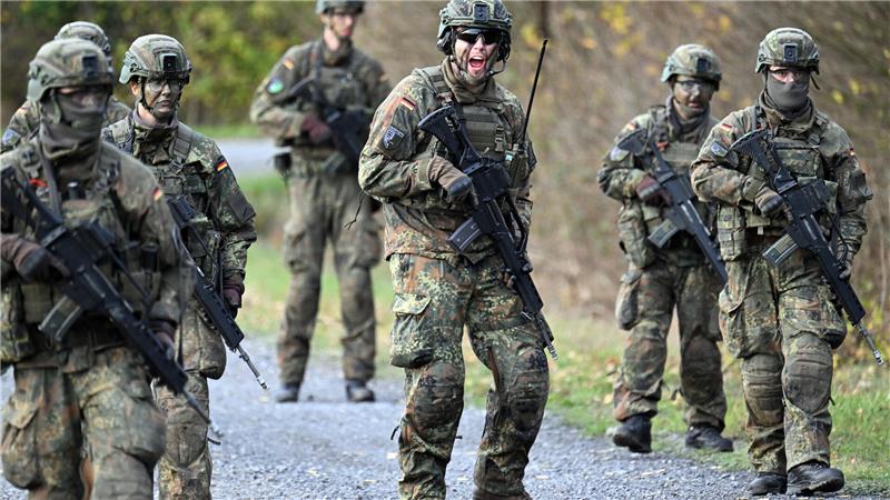 Rekruten in Uniform und mit Gewehren bei der Ausbildung.