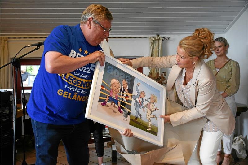 „Rente 2022“ prangt auf Burkhard Sieberts neuem T-Shirt in „XS“. Ein weiteres Geschenk gibt’s von Oberbürgermeisterin Urte Schwerdtner: eine Karikatur über gute und schlechte gemeinsame Zeiten. Humor macht im Leben bekanntlich vieles leichter. Foto: Kempfer