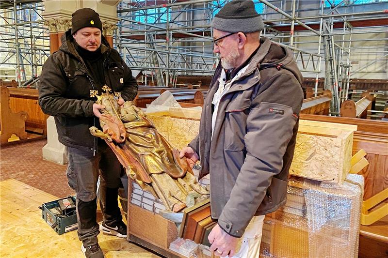 Harzburgs Lutherkirche ist für Sanierung (ein)gerüstet Restaurator Christoph Jarzebski verpackt mit seinem Kollegen die Marienfigur, die noch aus der Vorgängerkirche stammt, in einer eigens dafür gefertigten Holzkiste. Jarzebski ist Teil des Teams der Firma Windmann, die seit 2013 die historischen Quensen-Malereien in der Lutherkirche freilegen (rundes Bild). Fotos/Archivfoto: Nachtweyh