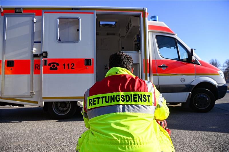 Unfall auf B191: ein Toter und zwei Schwerverletzte «Rettungsdienst» steht auf der Jacke eines Mannes vor einem Rettungswagen der Feuerwehr.