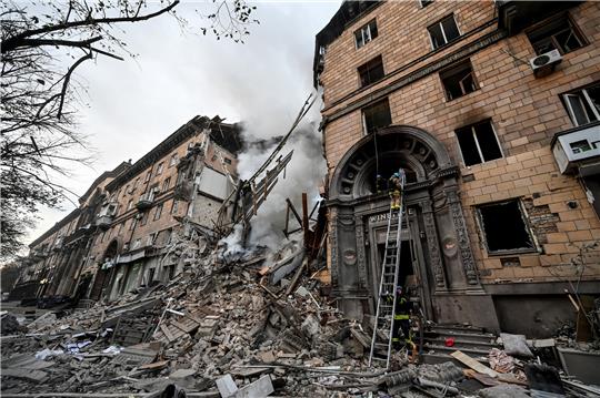Rettungskräfte arbeiten am Einsatzort eines durch Beschuss beschädigten Gebäudes. Foto: dpa