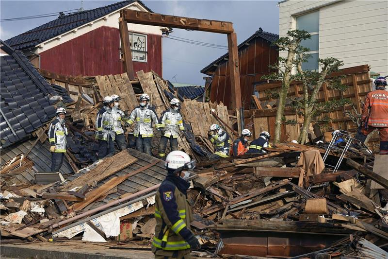 Rettungskräfte arbeiten an einem eingestürzten Gebäude in Wajima.