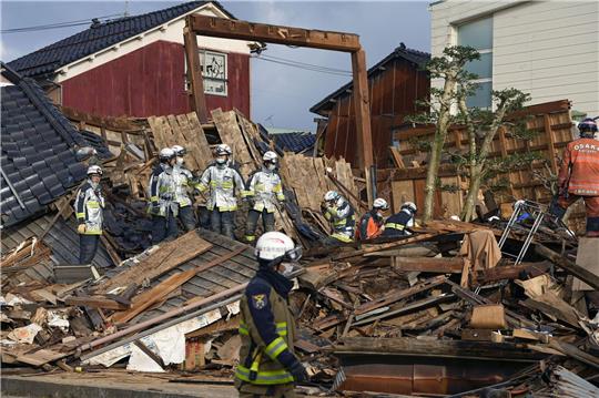 Rettungskräfte arbeiten an einem eingestürzten Gebäude in Wajima.