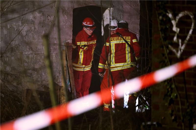 Abrissbagger in Lützerath - Widerstand bröckelt Rettungskräfte beraten vor eine Gebäude, in dem sich Personen in einem Tunnel verschanzt haben.