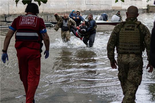 Rettungskräfte bringen verletzte Zivilisten in Sicherheit, die unter Beschuss der russischen Streitkräfte geraten waren.