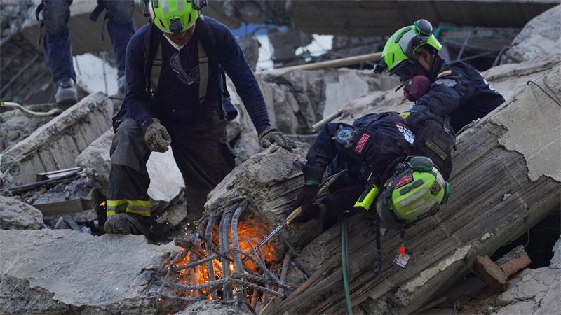 Rettungskräfte durchtrennen Trümmer bei der Suche nach Überlebenden.