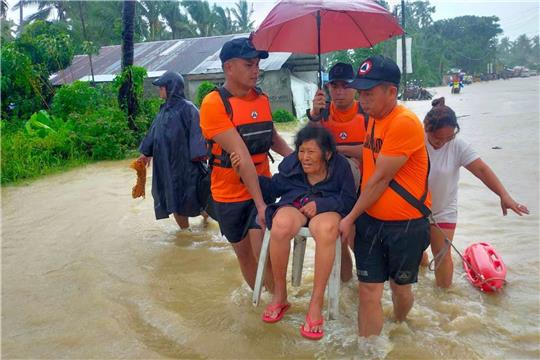 Rettungskräfte evakuieren Bewohner aus einem überschwemmten Gebiet auf den Philippinen.