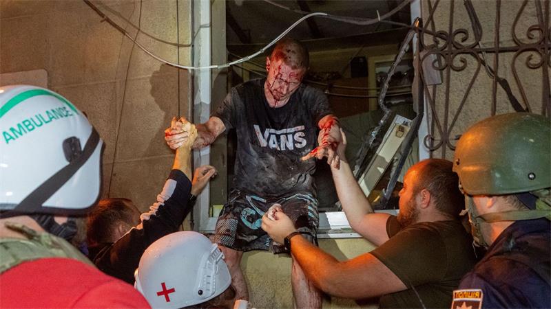Rettungskräfte evakuieren einen verletzten Zivilisten, nachdem ein Wohnhaus bei einem russischen Luftangriff in Charkiw getroffen wurde.