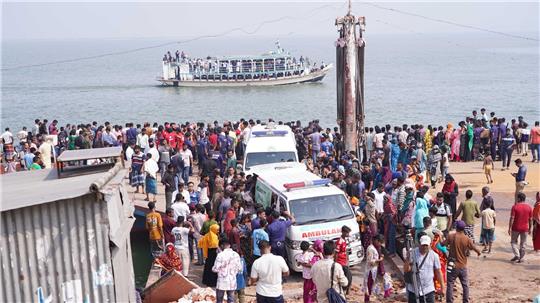 Rettungskräfte und zahlreiche Menschen versammeln sich an einer Unfallstelle, nachdem ein Bus in den Fluss Padma stürzte.