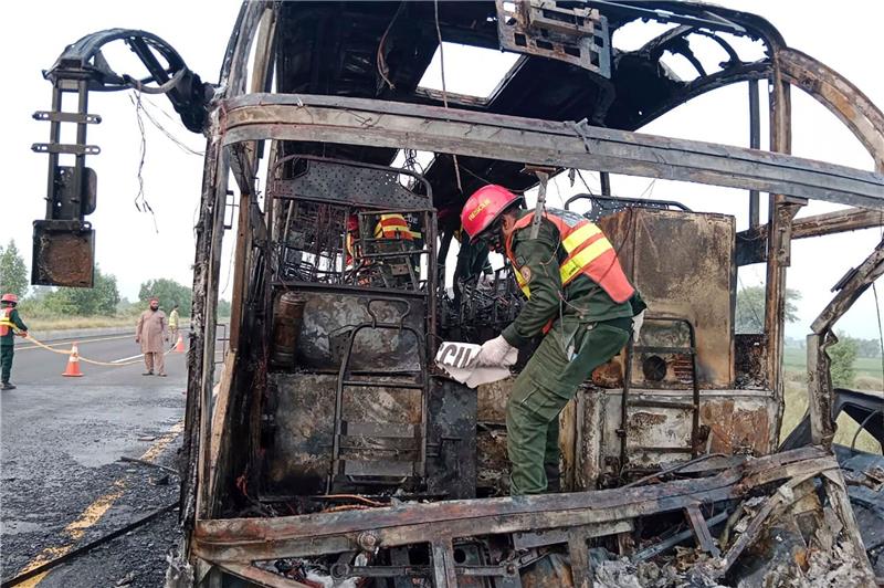 18 Tote nach Busbrand in Pakistan Rettungskräfte untersuchen den verbrannten Bus an der Unfallstelle auf einer Autobahn.