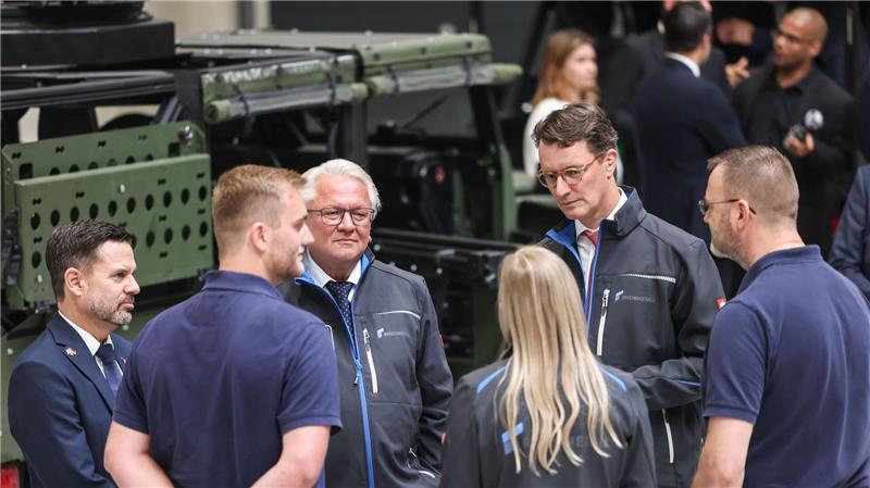 Rheinmetall-Chef Armin Papperger (Dritter von links) und NRW-Ministerpräsident Hendrik Wüst (zweiter von rechts) bei einem Rundgang durch die F-35-Produktionsanlage.