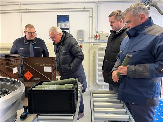 Vier Männer bei einer Werksbesichtigung.