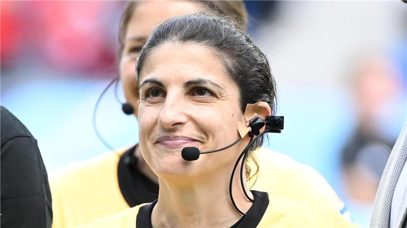 Die Schiedsrichterin Riem Hussein lächelt vor einem Spiel in die Kamera.