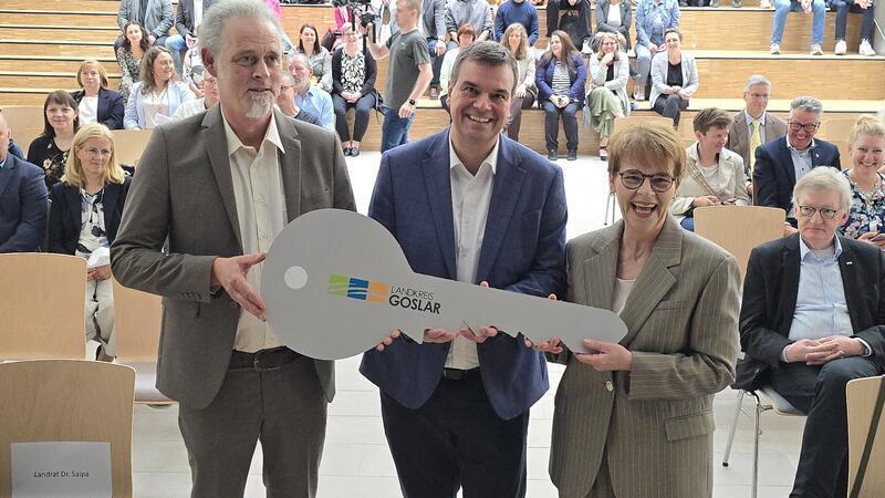 Riesiges Gebäude, großer symbolischer Schlüssel: CvD-Direktor Martin Ehrenberg (l.) und Realschulrektorin Ulrike Eilers (r.) übernehmen von Goslars Landrat Dr. Alexander Saipa.