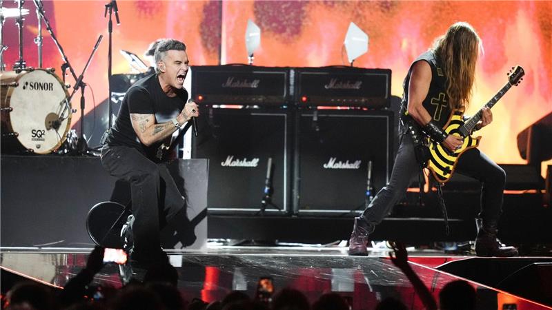 Robbie Williams (l) tritt während der Brit Awards 2026 in Manchester, England, auf.