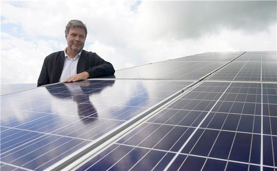 Robert Habeck (Bündnis 90/Die Grünen) steht zwischen Solarmodulen während seines Besuchs im Solarpark Klein Rheide.