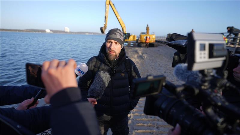 Robert Marc Lehmann spricht mit den Medien am Strand, in dessen Nähe der gestrandete Buckelwal im Wasser gelegen hatte.