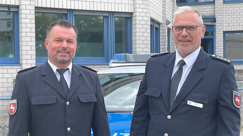 Das Bild zeigt links den neuen Leiter der Polizeiinspektion Goslar, Markus Iwa, und rechts den bisherigen Leiter Rodger Kerst in Uniform vor dem Hauptgebäude der Polizeiinspektion.