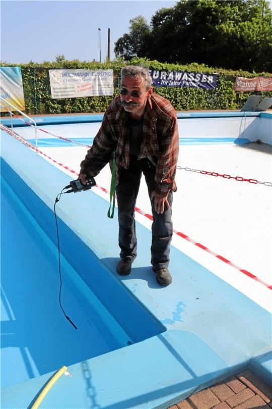 Rolf Palitza misst die Temperatur im Planschbecken. Foto: Hartmann