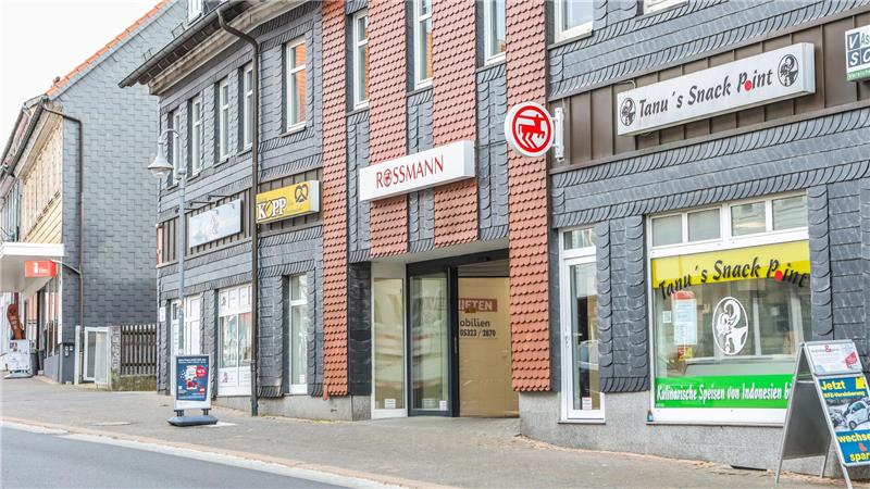 Zu sehen ist eine Häuserreihe mit Schaufenstern von Läden in der untersten Etage.