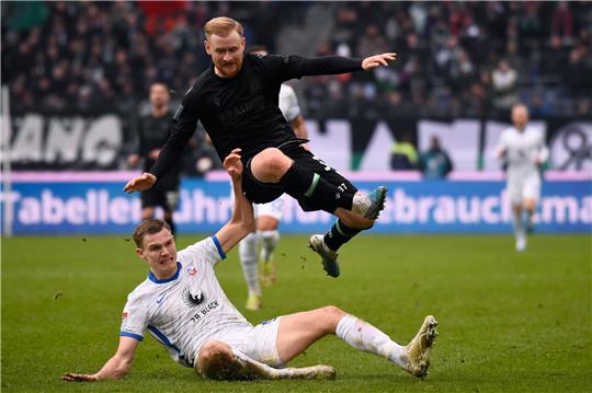Rostocks Svante Ingelsson (u) versucht Hannovers Sebastian Kerk den Ball abzunehmen.