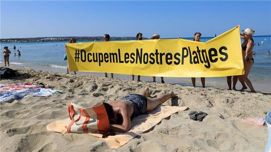 Rund 100 Aktivisten demonstrierten inmitten überraschter Strandurlauber gegen die Auswüchse des Massentourismus.