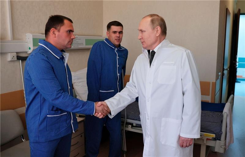 London: Kliniken in Russland leiden unter Aufwand für Krieg Russlands Präsident Wladimir Putin (r.) während eines Besuchs von verletzten Gefreiten im zentralen Militärkrankenhaus in Moskau.