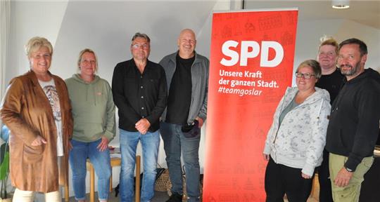 Sieben Personen stehen in einem Raum vor einem roten SPD-Aufsteller mit dem Text 'Unsere Kraft der ganzen Stadt. #teamgoslar'