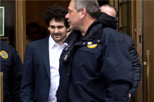 Sam Bankman-Fried (M) wird aus dem US-Bezirksgericht in Manhattan zu seinem Auto geführt.